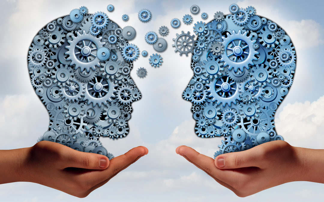 Filling the Skills Gap Photo: Is the image of two heads made of gears and transferring data to one another.